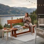 Brown wooden garden bench “Riva” with backrest for terrace use.